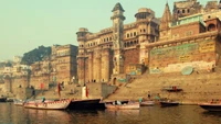 Historic Riverfront with Traditional Boats and Fortified Architecture