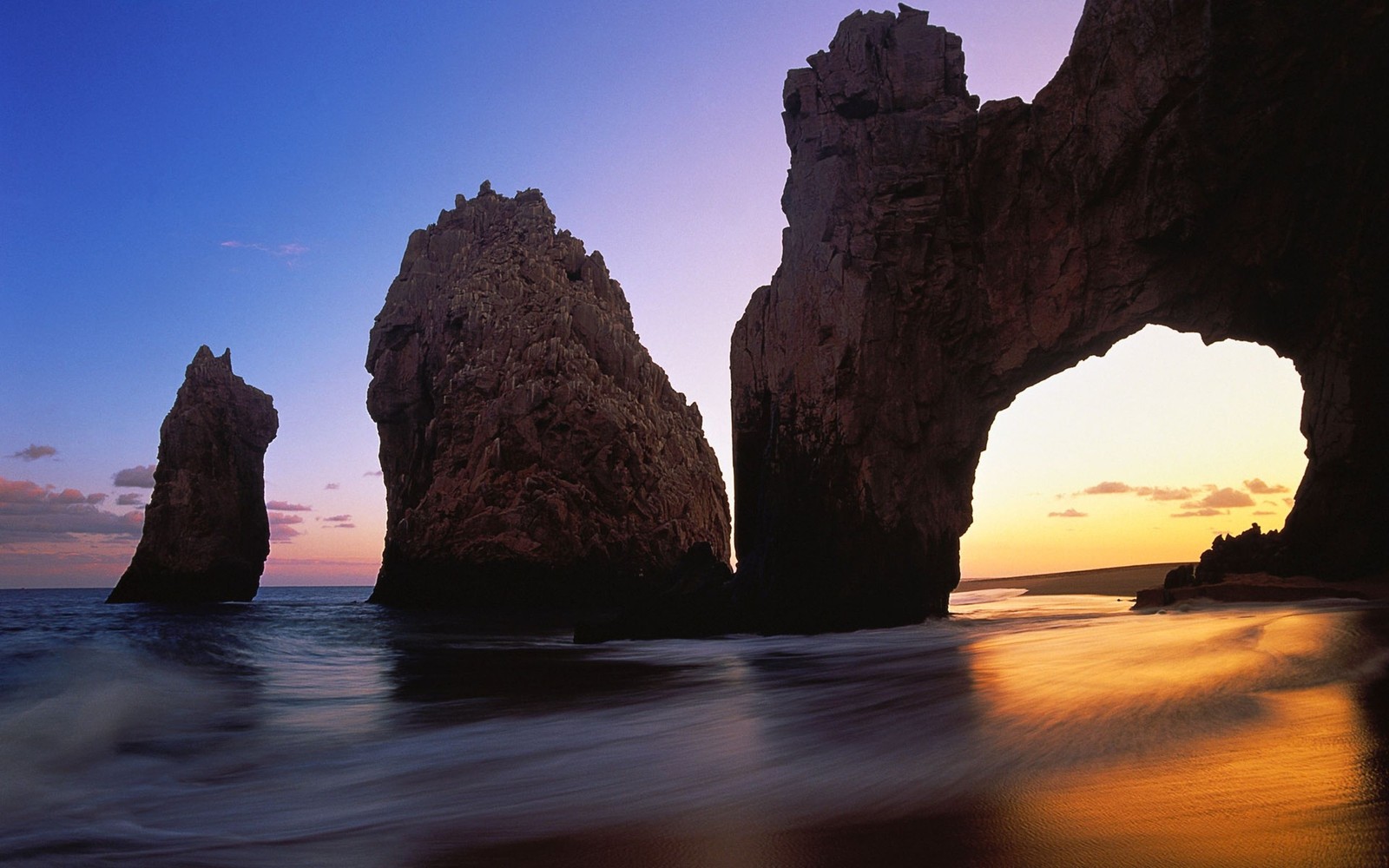 Rochas no oceano com um pôr do sol ao fundo (rocha, mar, horizonte, costa, estância)