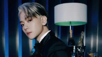 Baekhyun in a sophisticated pose, featuring a stylish outfit and a backdrop of cool blue lighting with a hint of luxury.