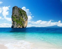 Majestic Rock Formation Against a Vibrant Blue Sea and Skies