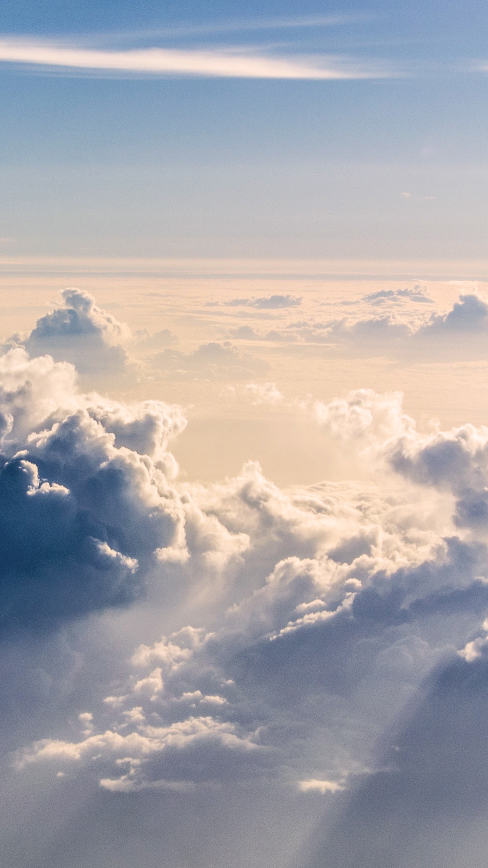 There is a plane flying over the clouds in the sky (blue, clouds, sky, sun)