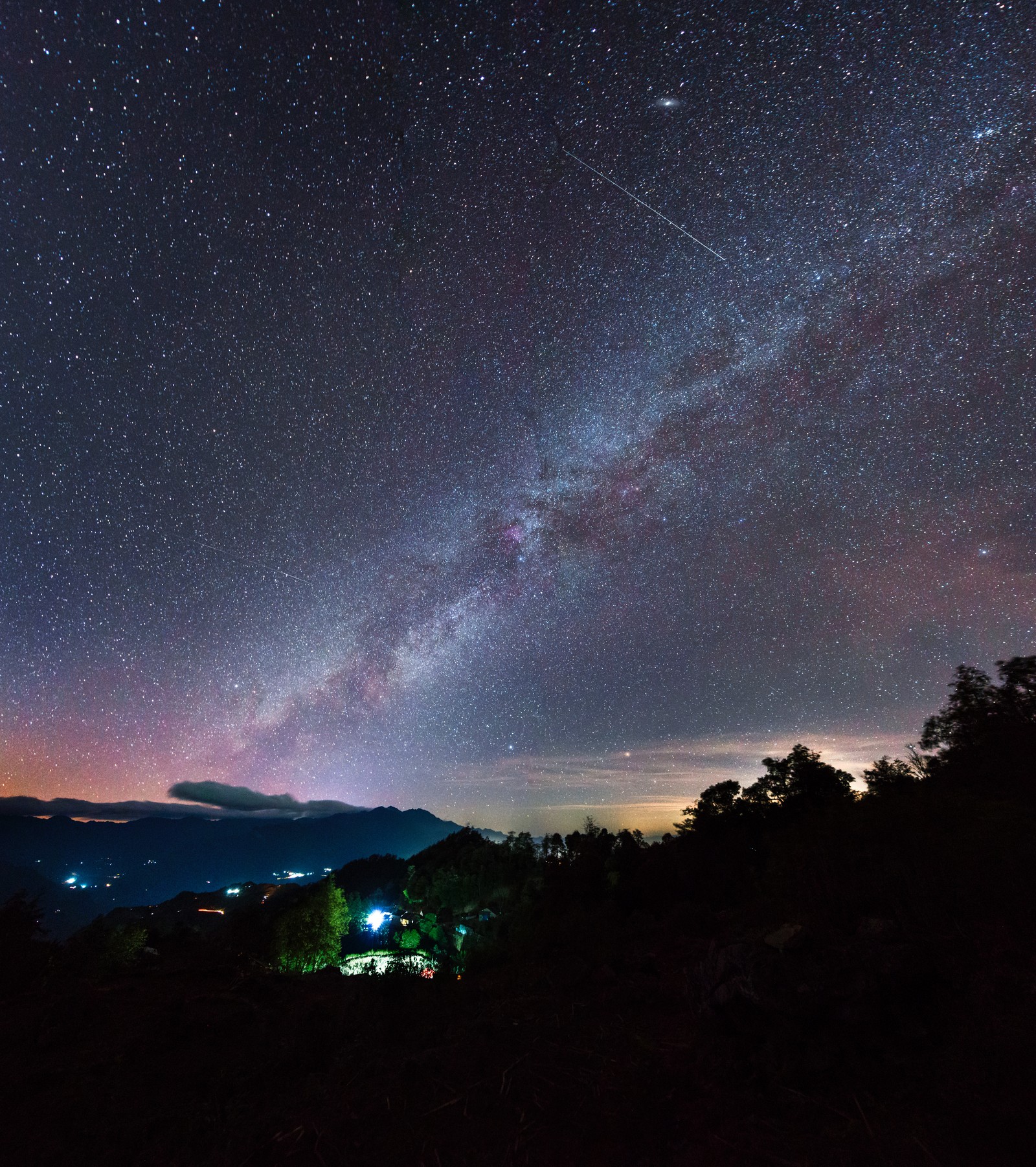 A via láctea sobre uma montanha com uma casa e árvores em primeiro plano. (estrela, noite, atmosfera, nuvem, astronomia)