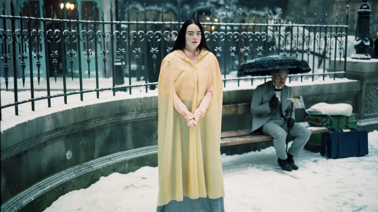 Eine frau steht im schnee mit einem regenschirm (arme dinge, film, emma stone)