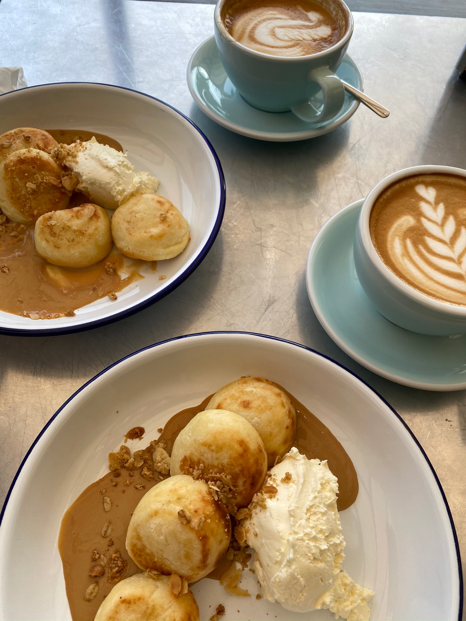 Il y a deux assiettes de nourriture sur une table avec une tasse de café (plat, petit déjeuner, dessert, brunch, tasse à café)