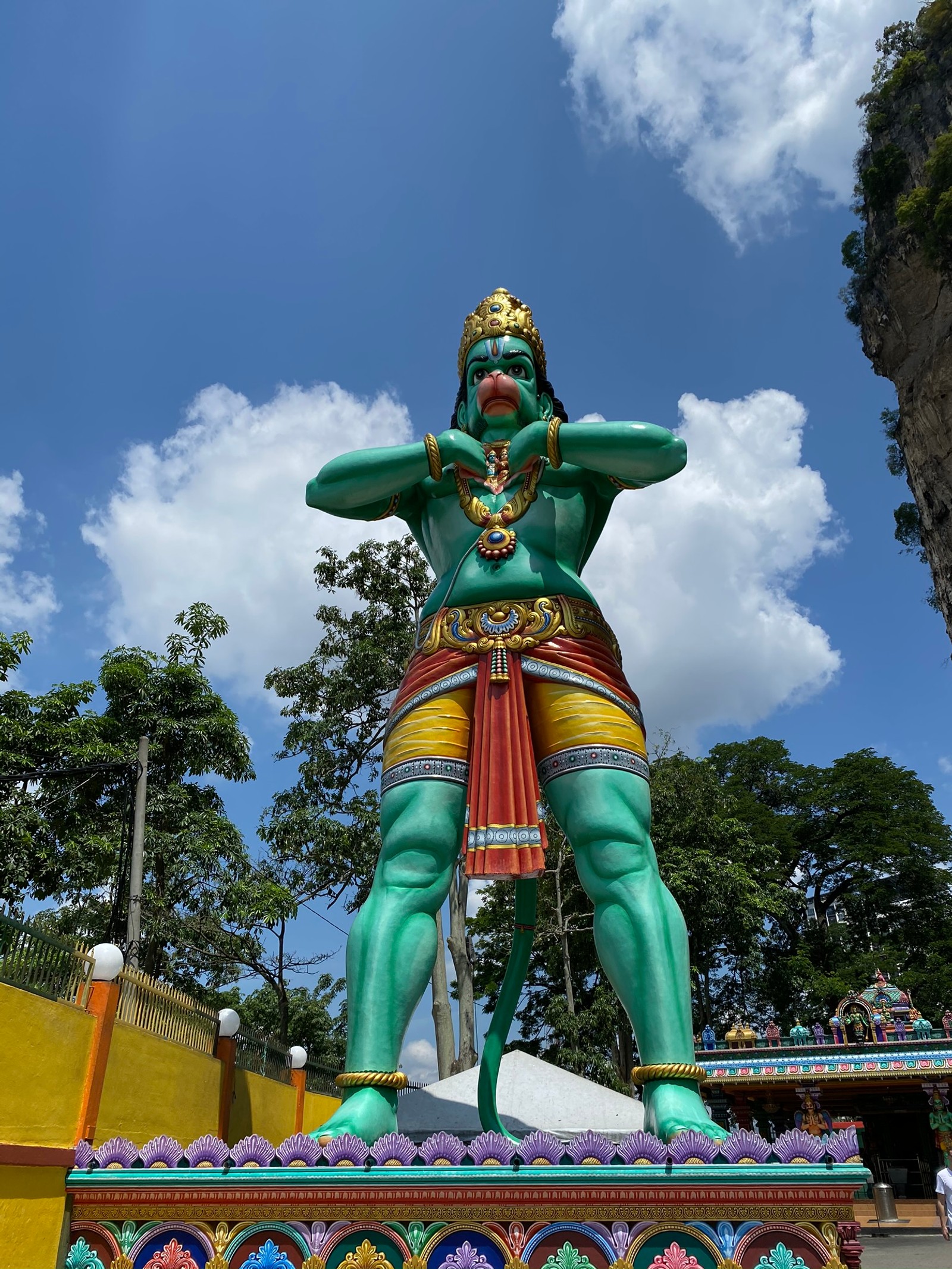 Uma escultura de um homem com uma grande cabeça e braços grandes (estátua, atração turística, turismo, parque de diversões, verde)