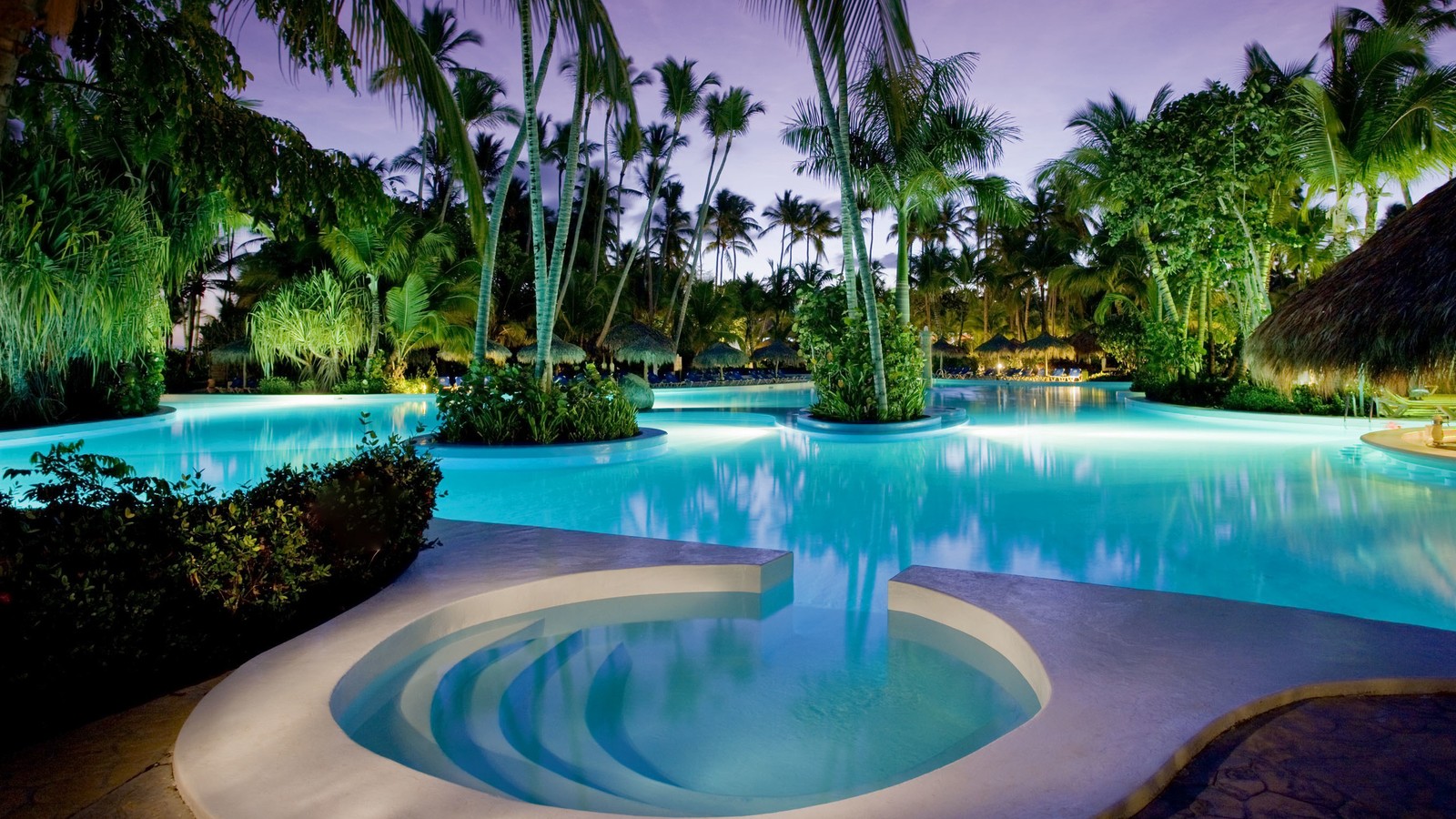 Une grande piscine avec une cascade au milieu. (station, plage, piscine, loisir, eau)