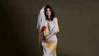 Alexandra Daddario em um vestido drapeado colorido contra um fundo neutro - 2024