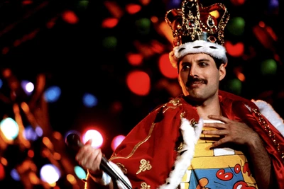 Freddie Mercury in einer königlichen Krone und einem Umhang, der während einer lebhaften Aufführung Charisma ausstrahlt.