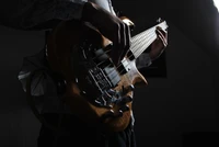 Silhouette of a musician playing a bass guitar, showcasing craftsmanship and passion for music.