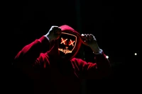 Anonymous Figure in LED Mask and Hoodie Against a Dark Background