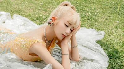 Yoon Bomi de la sous-unité Apink, captivante dans une pose rêveuse sur une herbe verte luxuriante