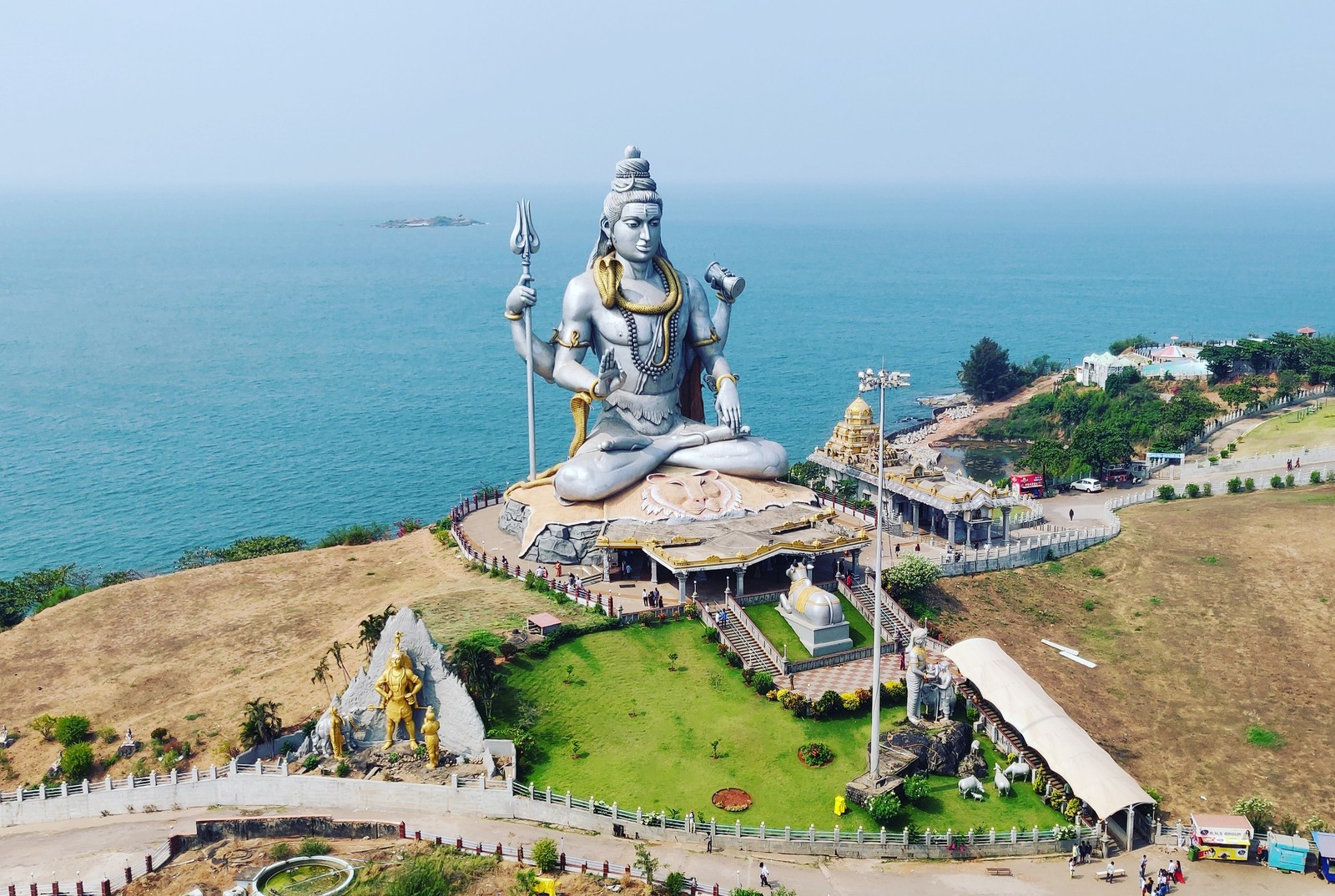 Uma grande estátua de um homem sentado no topo de uma colina (bholenath, deus, har har mahadev, senhor shiva, lord shiva)