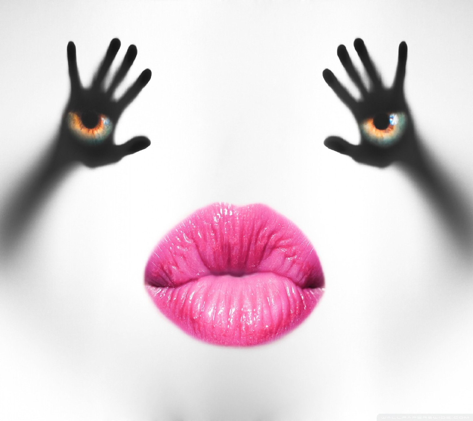 Someone is holding their hands up to a pink lip with a creepy eye (optical illusion)