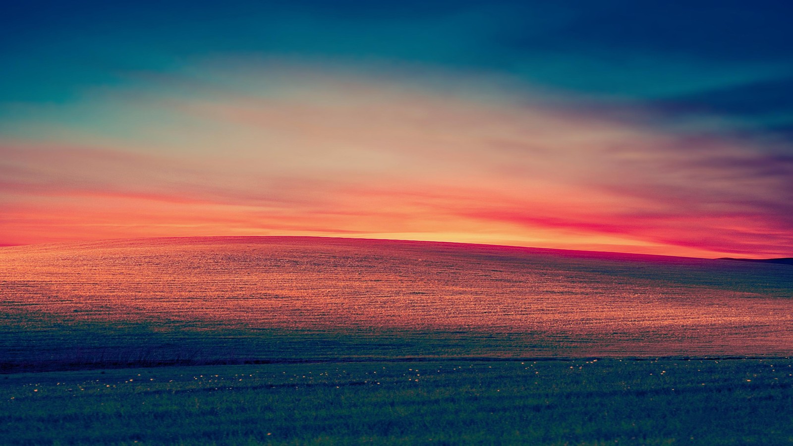 Uma vista de um campo com um pôr do sol ao fundo (por do sol, pradaria, paisagem, cenário)