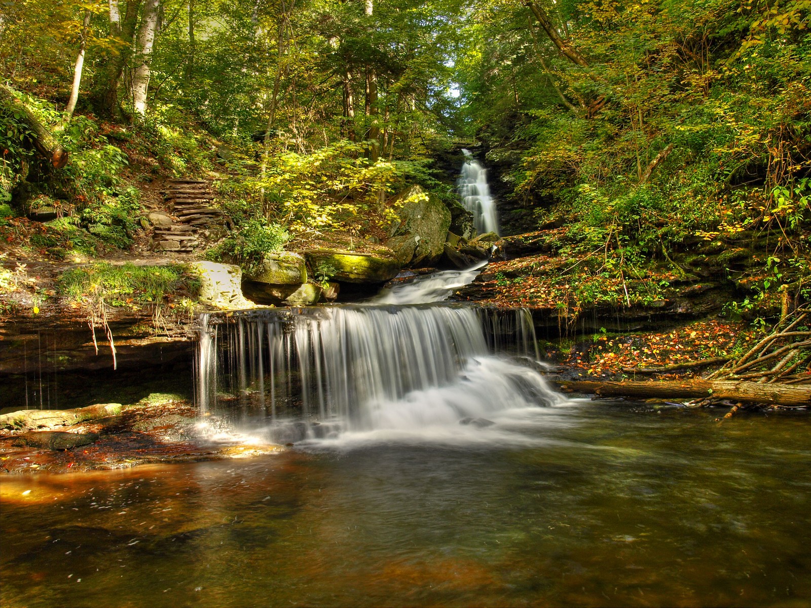 Arafed wasserfall im wald mit einem wasserfall im vordergrund (wasserfall, wasserlauf, naturschutzgebiet, vegetation, gewässer)