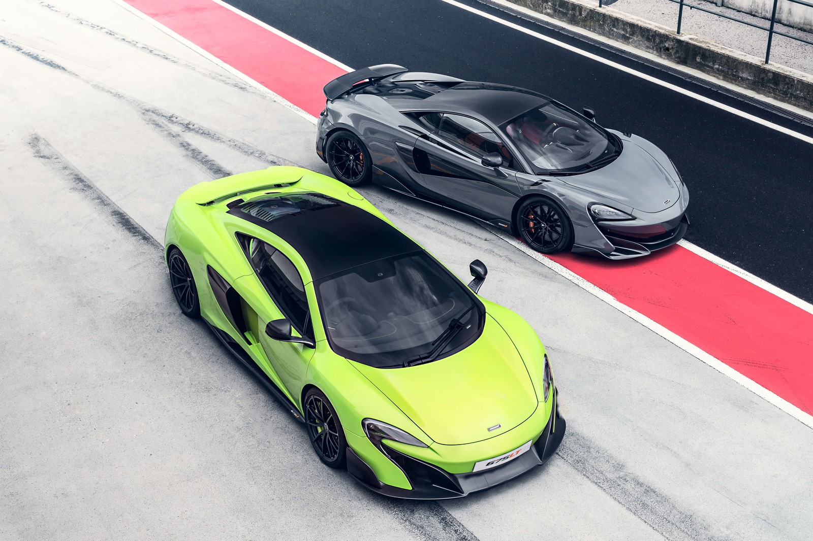 Two cars are parked on a track next to each other (supercar, mclaren, sports car, car, mclaren automotive)