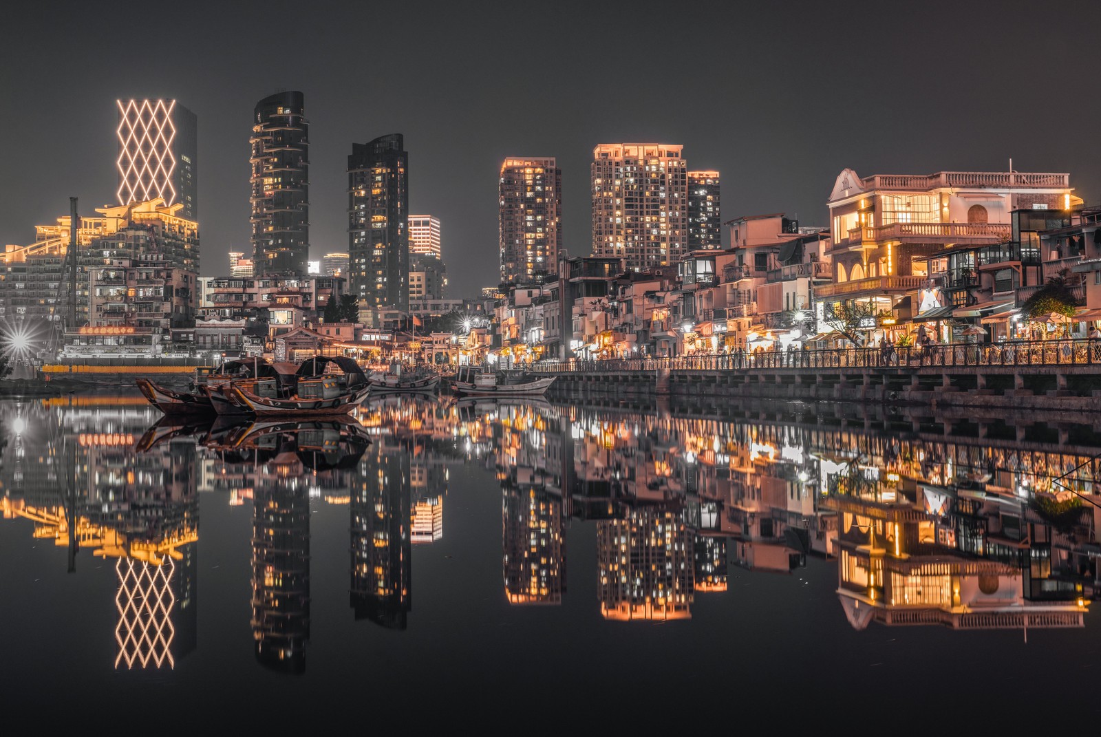 Vista aérea de una ciudad por la noche con un barco en el agua (skyline de la ciudad de hong kong, noche, iluminación, luces nocturnas, 5k)