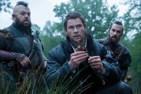 Chris Hemsworth as a soldier in 'Snow White and the Huntsman' amidst a forest backdrop