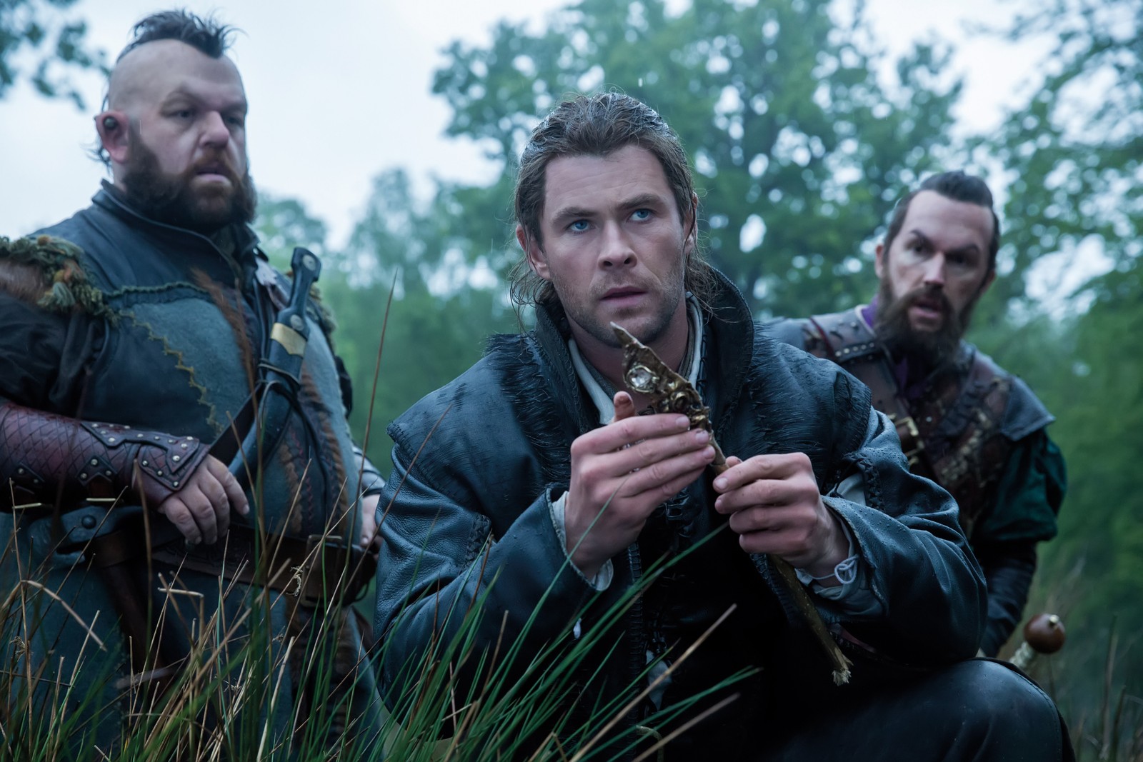 Image arabe de trois hommes en vêtements médiévaux assis dans un champ (chris hemsworth, snow white and the huntsman, soldat, film, herbe)