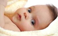 Adorable Infant with Expressive Eyes Wrapped in Soft Blanket