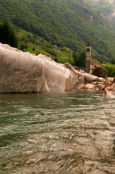 Serene Flusslandschaft mit Steinvorsprünge und historischer Kirche