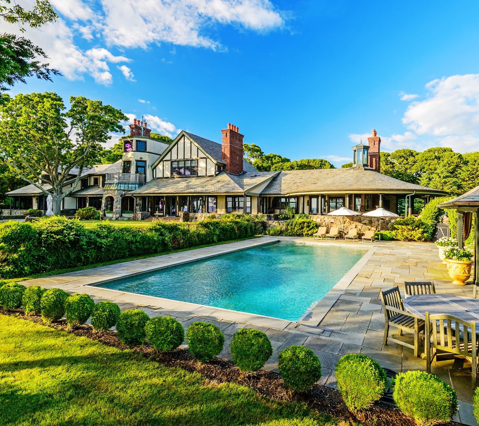 A large pool sits in the middle of a lush green yard (home, life, luxury, pool)