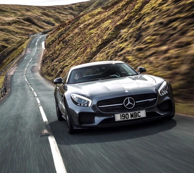 Mercedes AMG GT em uma estrada sinuosa através de colinas cênicas.