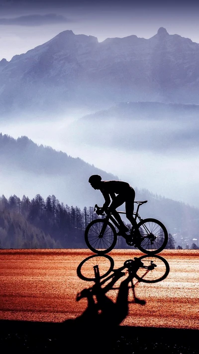 Silueta de ciclista contra majestuosas montañas al anochecer