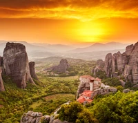 Pôr do sol sobre uma paisagem montanhosa com uma casa isolada