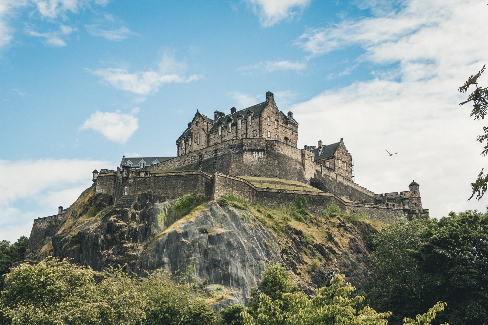 Ein großes schloss auf einem hügel mit bäumen und blauem himmel (burg, wolke, gebäude, berg, natürliche landschaft)