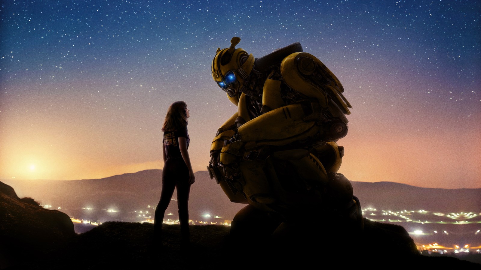 A woman standing next to a giant robot on top of a hill (robot, bumblebee, transformers, paramount pictures, autobot)