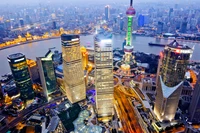 Une vue à couper le souffle de la skyline vibrante de Shanghai, avec des gratte-ciels frappants, des monuments illuminés et la rivière sinueuse qui renforce le charme métropolitain de la ville.