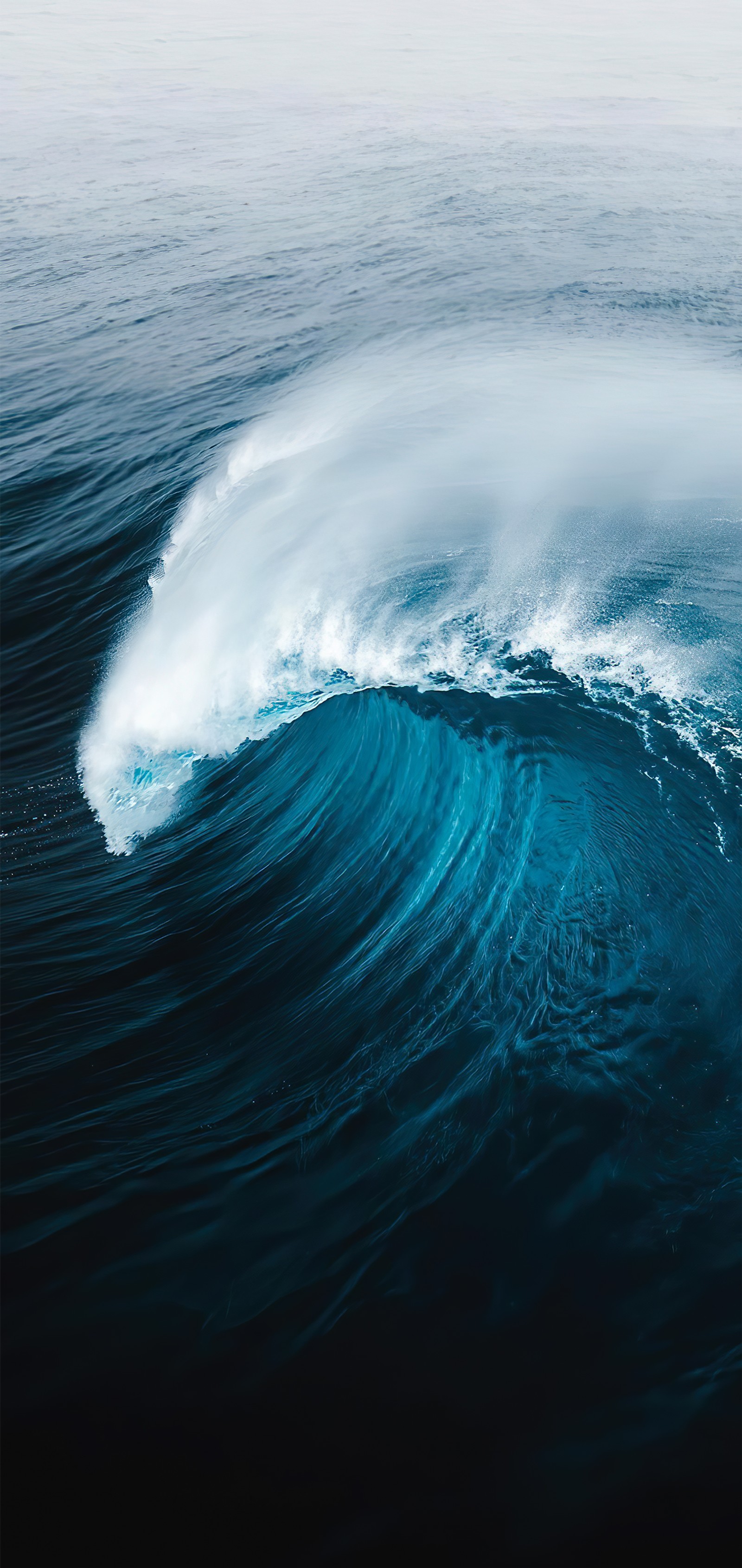 Surfer reitet auf einer großen welle im ozean an einem bewölkten tag. (welle, wasser, flüssigkeit, azurblau, aqua)