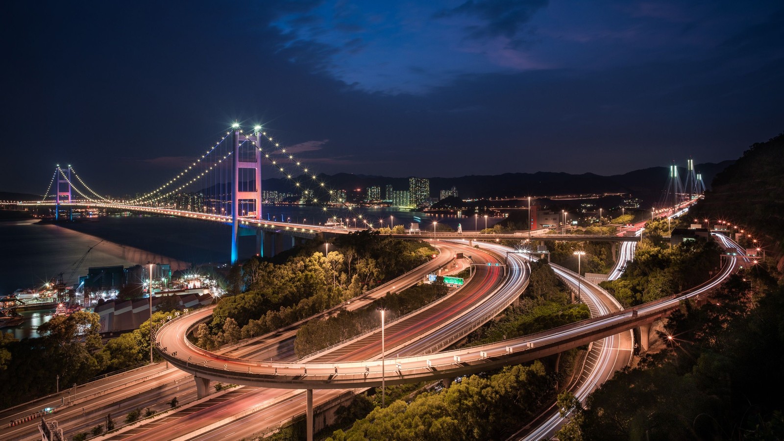 Blick auf die bay bridge bei nacht von der spitze eines hügels (tsing ma brücke, hängebrücke, brücke, nacht, stadtgebiet)