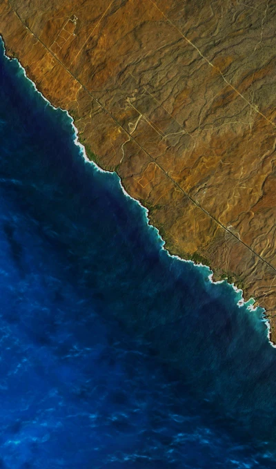 Aerial view of a rugged coastline meeting vibrant ocean waters.