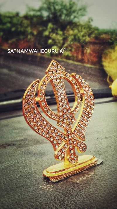 Un símbolo Khanda brillante adornado con strass, que representa la fe y la espiritualidad en la cultura religiosa punjabi.