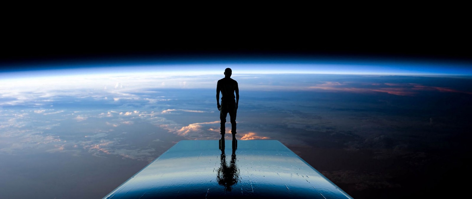 Vue aérienne d'un homme debout sur un long morceau de verre (atmosphère, terre, planète, espace, lumière)