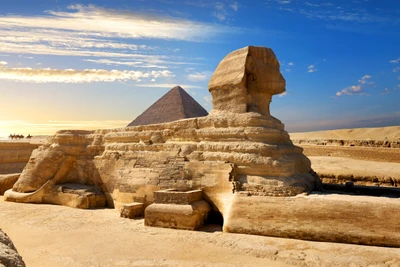 Le Grand Sphinx de Gizeh avec la Grande Pyramide en arrière-plan, sur fond d'un ciel dramatique, met en valeur l'histoire ancienne et l'architecture monumentale au Caire.