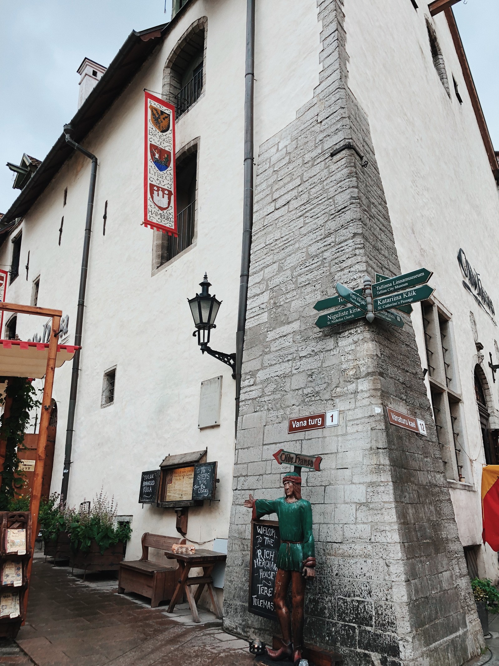 Ein mann steht vor einem gebäude mit einem schild (alter markt, straße, architektur, blau, grün)