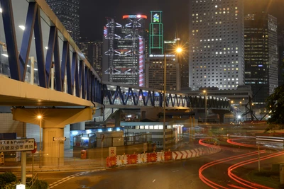 Paisaje urbano vibrante nocturno de Hong Kong con rascacielos y movimiento urbano.