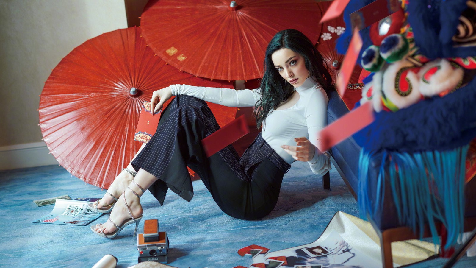 Une femme assise par terre avec un parapluie (emma dumont, beau, actrice, célébrité, femmes)