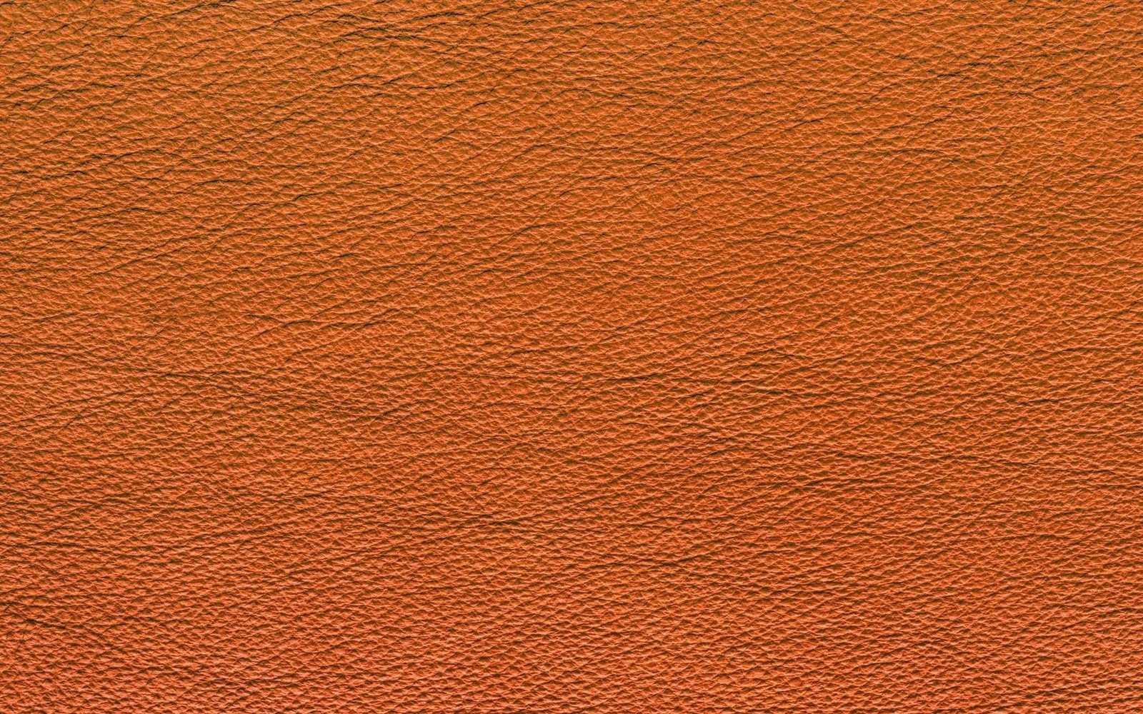 An orange leather background with a very rough texture (orange, brown, wood, wood stain, pattern)