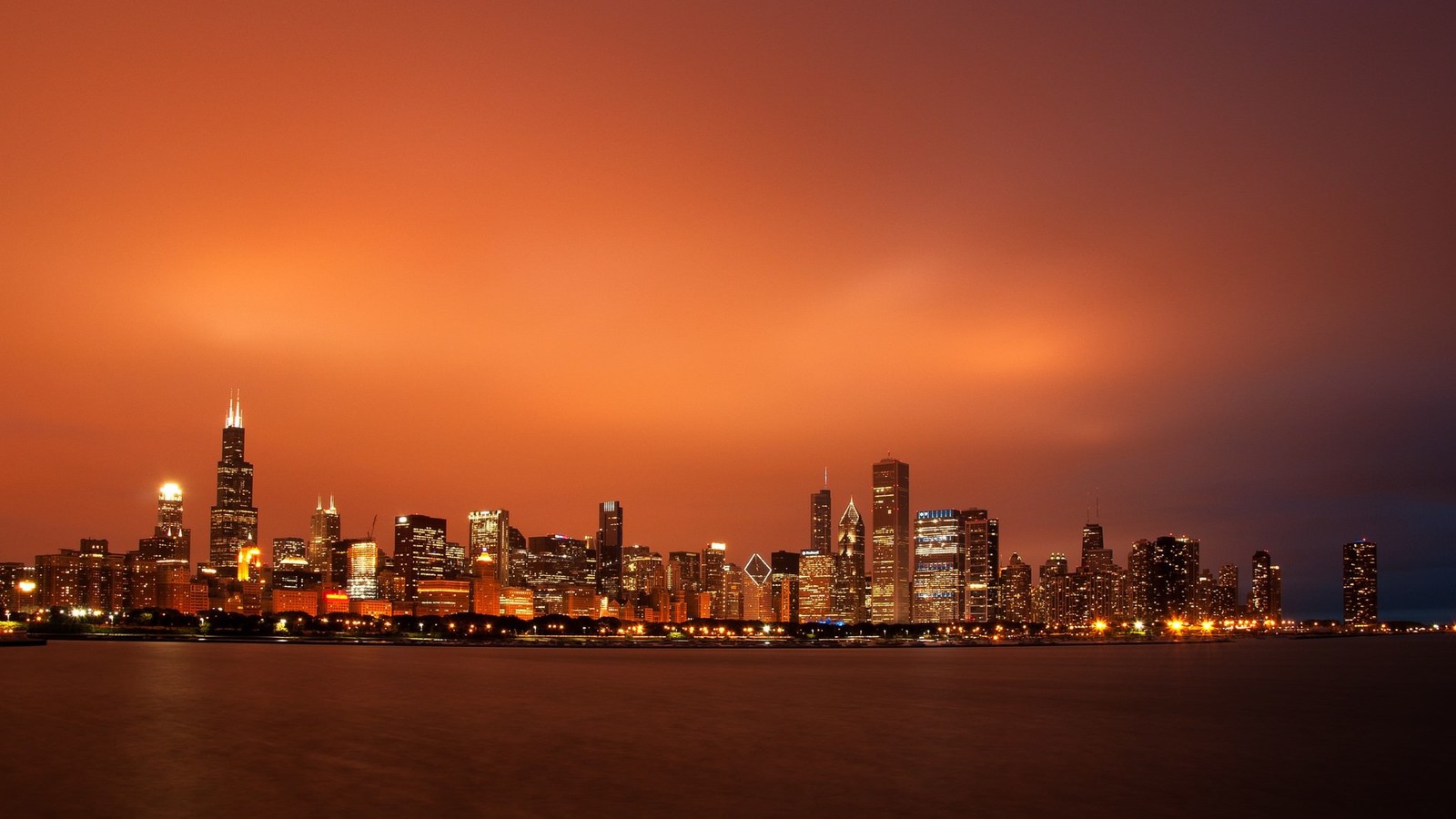 Una vista del horizonte de la ciudad por la noche con un cielo rojo (chicago, rascacielos, ciudad, paisaje urbano, panorama)